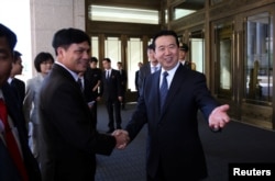 Meng Hongwei (R), Chinese vice public security minister, shakes hands with Nguyen Quang Dam, the commandant of the Vietnam Coast Guard, in Beijing, China, August 26, 2016.