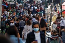 People wearing protective face masks walk in a busy street in Paris as France reinforces mask-wearing in public places as part of efforts to curb a resurgence of the coronavirus disease (COVID-19) across France, September 18, 2020.
