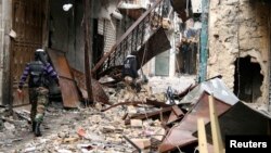 Free Syrian Army members walk through damaged buildings near the Great Mosque, or Umayyad Mosque, Aleppo, Feb. 11, 2013.