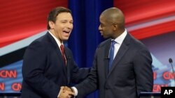 Florida Republican gubernatorial candidate Ron DeSantis, left, shakes hands with Democratic gubernatorial candidate Andrew Gillum after a CNN debate, Sunday, Oct. 21, 2018, in Tampa, Florida.