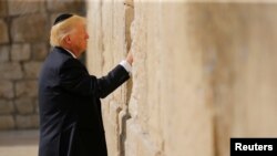 Le président américain Donald Trump glisse une note dans les pierres du mur des lamentations à Jérusalem, le 22 mai 2017.