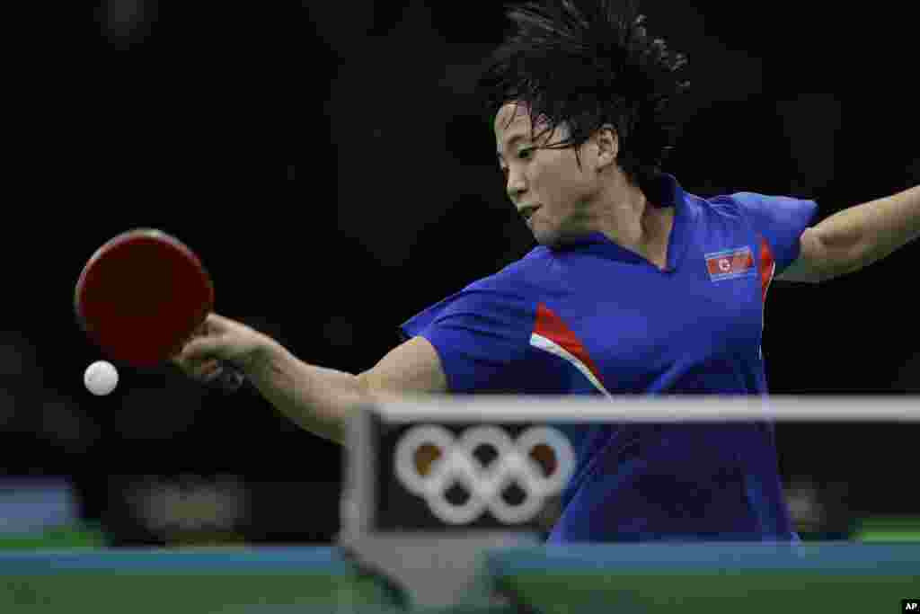 Kim Song I dari Korea Utara bertanding melawan Ai Fukuhara dari Jepang dalam untuk mendapatkan medali perunggu tenis meja putri (10/8). (AP/Petros Giannakouris)