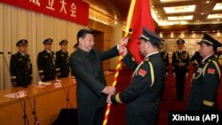中国国家主席习近平（左前）在北京举行的中国人民解放军战区成立大会上向五大战区授予军旗。（2016年2月1日）