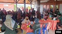 Warga Desa Bulukerto memeriksakan diri ke dokter di Posko Kesehatan (foto Petrus Riski-VOA).