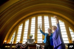 Democratic presidential candidate Hillary Clinton, accompanied by Sen. Elizabeth Warren, D-Mass., left, waves after speaking at the Cincinnati Museum Center at Union Terminal in Cincinnati, June 27, 2016.