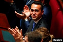 FILE - 5-Star Movement leader Luigi Di Maio applauds the new Chamber of Deputies president, Roberto Fico, during the second session of parliament since the March 4 national election in Rome, Italy, March 24, 2018.
