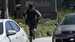 Officers run toward a YouTube office in San Bruno, California, April 3, 2018. 