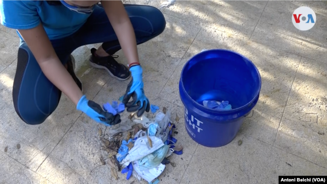 La joven colombiana suele recoger unos 30 guantes y mascarillas al día.