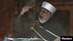 Sufi cleric and leader of the Minhaj-ul-Quran religious organisation Muhammad Tahirul Qadri addresses his supporters from behind the window of an armored vehicle on the second day of protests in Islamabad, January 15, 2013.