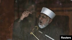 Sufi cleric and leader of the Minhaj-ul-Quran religious organisation Muhammad Tahirul Qadri addresses his supporters from behind the window of an armored vehicle on the second day of protests in Islamabad, January 15, 2013.