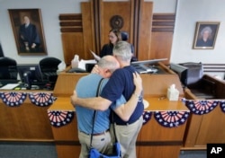 FILE - After the U.S. Supreme Court ruled that same-sex couples have the right to marry nationwide, Gerald Gafford, right, and his partner of 28 years, Jeff Sralla, receive a waiver allowing them to marry, in Austin, Texas, June 26, 2015.