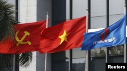 越南国家油气集团（PetroVietnam）总部前的越南共产党旗、越南国旗和油气集团旗帜（由左向右）