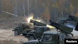 FILE - Ukrainian servicemen fire BM-21 Grad multiple rocket launcher systems during military exercises near the village of Divychky in the Kyiv region of Ukraine, Oct. 28, 2016.