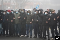 Demonstrators stand in front of a police line during a protest in Almaty, Kazakhstan, Jan. 5, 2022.