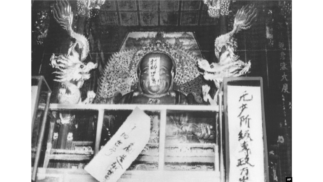 历史照片:红卫兵给杭州灵隐寺的佛像贴上“打碎旧世界”等标语。(1966年8月27日)