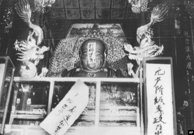 历史照片：红卫兵给杭州灵隐寺的佛像贴上“打碎旧世界”等标语。(1966年8月27日)