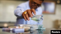 Seorang pegawai Bank Indonesia menghitung lembaran uang rupiah di kantor pusat di Jakarta. 