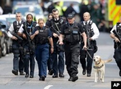 Policías armados resguardan una zona acordonada luego de los ataques en el Puente de Londres y en un área cercana.