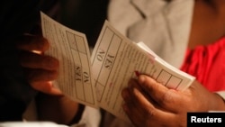 A Zimbabwean election official counts ballot papers after the close of voting on a referendum to approve a new constitution, in Harare, March 16, 2013. 