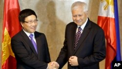 FILE - Philippine Foreign Affairs Secretary Albert Del Rosario, right, welcomes Vietnamese Foreign Minister Pham Binh Minh for their 7th Meeting of the Philippines-Vietnam Joint Commission for Bilateral Cooperation (JCBC) in Manila, Philippines, Aug. 1, 2013 .