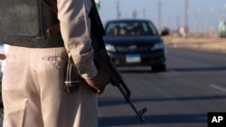 Un policier, arme en bandoulière, assure la sécurité près de la route de la cathédrale à Minya, Egypte, 26 mai 2017.