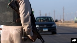 Un policier, arme en bandoulière, assure la sécurité près de la route de la cathédrale à Minya, Egypte, 26 mai 2017.