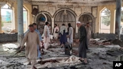 8일 아프가니스탄 북부 쿤두즈의 시아파 이슬람 사원 폭발 현장을 관계자들이 둘러보고 있다.