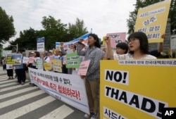 Protesters shout slogans during a rally to denounce deploying the Terminal High-Altitude Area Defense, or THAAD, in front of the Defense Ministry in Seoul, South Korea, Wednesday, July 13, 2016.