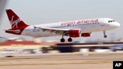 FILE - A Virgin America's flight between Los Angeles and Dallas is seen coming in for a landing at Dallas Fort Worth International Airport in Grapevine, Texas, Dec. 1, 2010. Alaska Air Group Inc. is eyeing to buy Virgin America in a deal valued at $4 bill