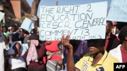 A young woman holds a placard during a march for free basic education in Bulawayo, Zimbabwe.
