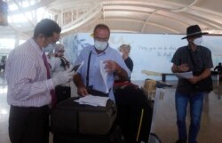 Warga Australia diperiksa oleh petugas keamanan saat keberangkatan di Bandara Internasional Ngurah Rai, Bali, Rabu, 18 Agustus 2021.