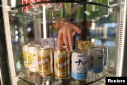 A vendor adjusts cans of soft drinks made by Air Koryo, at the airport in Pyongyang, North Korea, April 11, 2017.