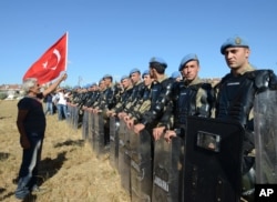 A protester argues at a paramilitary police barricade as security block thousands of people outside the Silivri jail complex in Silivri, Turkey, Aug. 5, 2013.