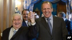El ministro de Exteriores ruso, Sergey Lavrov (derecha) y su contraparte siria, Walid al-Maolem entran a un salón de la mano, para conversar en Moscú.