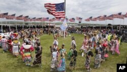 Para penduduk asli Amerika dari 20 tempat pelestarian penduduk di berbagai wilayah North dan South Dakota, mempersembahkan tarian menjelang kedatangan Presiden Barack Obama dan ibu negara Michelle Obama di Standing Rock Indian Reservation, Cannon Ball, North Dakota (13/6).