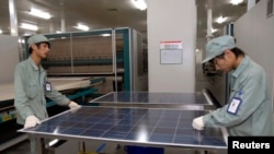 FILE - Employees work on a solar panel production line at Suntech Power Holdings headquarters in Wuxi, Jiangsu. The past few years has seen a plethora of trade disputes as China-made environmental equipment, including solar panels, flooded into western markets. 