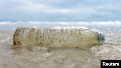 FILE - A plastic bottle washed up by the sea is seen at the Ao Phrao Beach, on the island of Ko Samet, Thailand, June 10, 2018. 