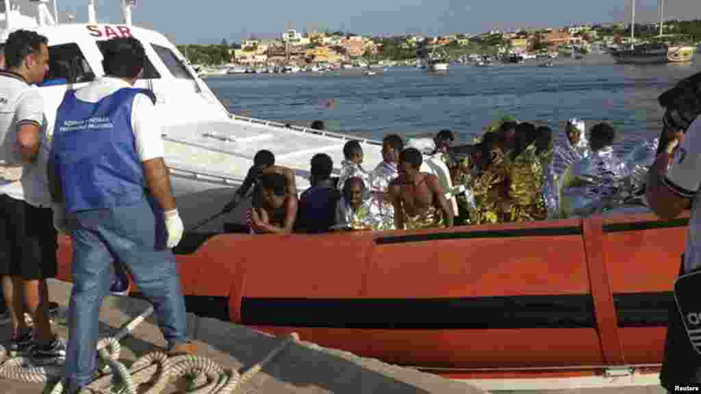 Rescued migrants arrive onboard a coast guard vessel at the harbor of Lampedusa, Italy, Oct. 3, 2013. (Nino Randazzo/ASP press office)