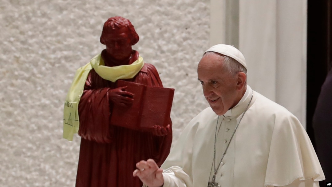 Sweden Pope's Visit: In this photo taken on Oct. 13, 2016, Pope Francis passes by a statue portraying Martin Luther as he arrives for an audience with Lutheran pilgrims at the Vatican. Pope Francis travels to Sweden next week to commemorate the split in Western Christianity 500 years ago.