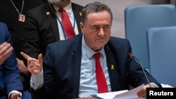 FILE - Israel Foreign Minister Israel Katz points at family members of hostages during a meeting at UN headquarters in New York, March 11, 2024. He warned Iran Wednesday not to attack Israel from Iranian territory, 