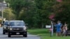 Una familia saluda el paso de una caravana que se dirige a la casa de playa del presidente Joe Biden, el domingo 21 de julio de 2024, en Rehoboth Beach, Delaware. Biden abandonó la carrera de 2024 para la Casa Blanca el domingo.