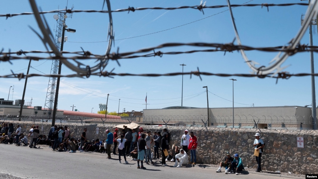 Migrantes esperan frente a una oficina de inmigración de EEUU cerca de El Paso, Texas, para ser procesados tras la eliminación del Título 42 el 9 de mayo de 2023.