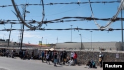 Migrantes esperan frente a una oficina de inmigración de EEUU cerca de El Paso, Texas, para ser procesados tras la eliminación del Título 42 el 9 de mayo de 2023.
