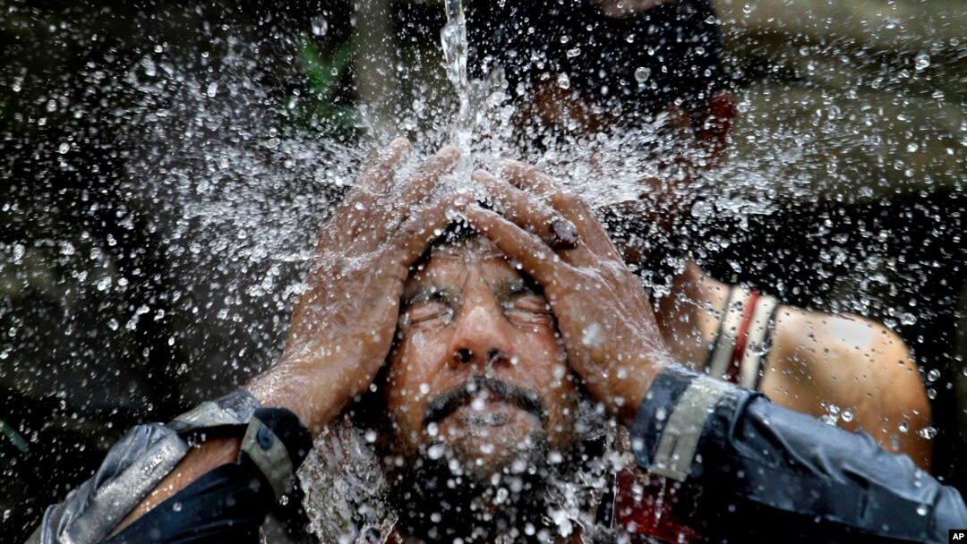 A Pakistani man cools himself off under a water supply to beat the heat during the holy fasting month of Ramadan, in Islamabad, Pakistan, June 7, 2016. 