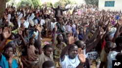 FILE - Members of the LRA community living at Koch Goma IDP camp in Gulu, Northern Uganda raise their hands after having been asked if they were ready to forgive the atrocities of the past 20 years.