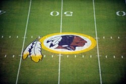 FILE - The Washington Redskins logo is shown on the field before the start of a preseason NFL football game against the New England Patriots in Landover, Md., Aug. 28, 2009.