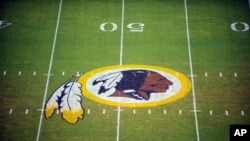 FILE - The Washington Redskins logo is shown on the field before the start of a preseason NFL football game against the New England Patriots in Landover, Md.