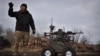 In this photo provided by Ukraine's 65th Mechanized Brigade press service, a serviceman explains how to operate a Gnom 2 ground drone in Zaporizhzhia region, Ukraine, on Nov. 29, 2024.