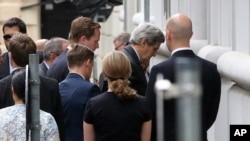 U.S. Secretary of State John Kerry, second right, arrives at Palais Coburg where closed-door nuclear talks with Iran take place in Vienna, Austria, July 8, 2015. 