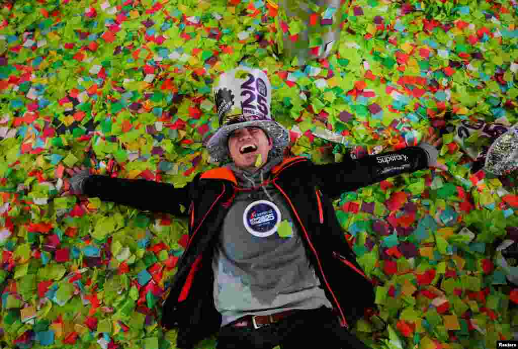 A man reacts while lying on top of confetti after the ball drop at Times Square during New Year&#39;s celebrations in New York City.